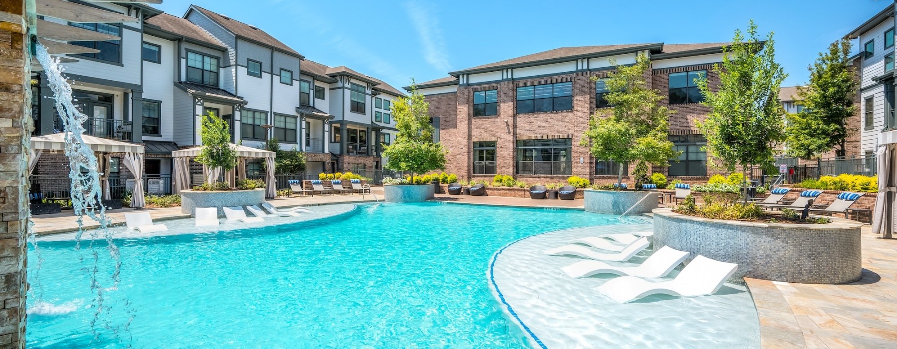 a pool in a courtyard with chairs and umbrellas