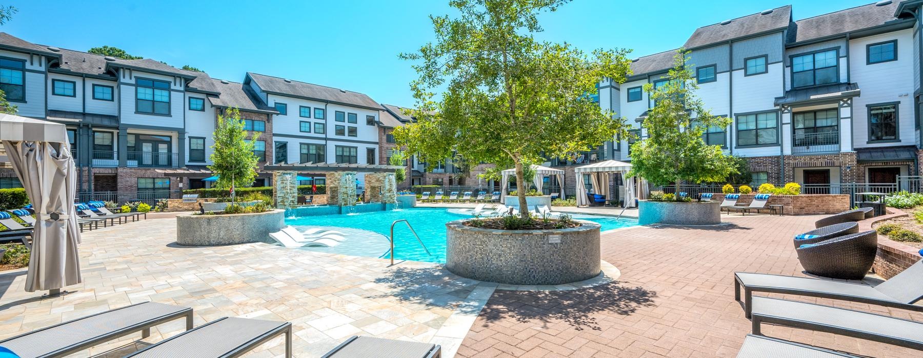 a pool in a courtyard with chairs and umbrellas